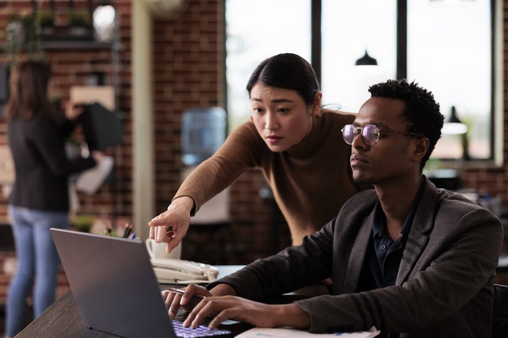 two coworkers on computer using cloud migration consulting services to access files