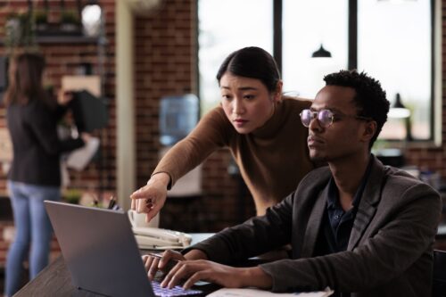 two coworkers on computer using cloud migration consulting services to access files